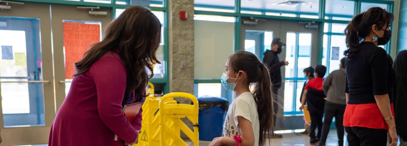 student speaking to school staff in hallway
